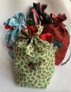 three small bags with bows on them are lined up next to each other in different colors