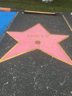 a pink star on the ground with writing written in it