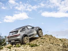 a silver suv driving on top of a rocky hill