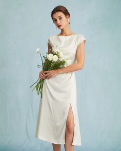 a woman in a white dress holding flowers