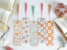 four bookmarks are lined up on a table next to an open book and donut