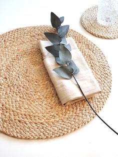 a place mat with a napkin and some leaves on it, sitting on a table