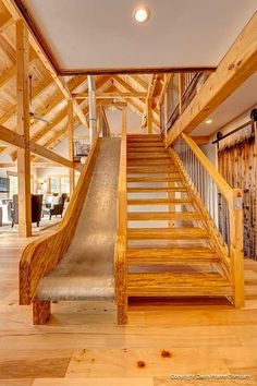 an indoor slide in the middle of a room with wood floors and walls on both sides