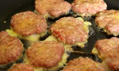 hamburger patties cooking in a skillet with melted cheese