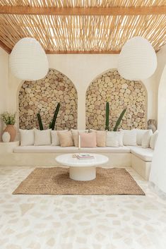 a living room filled with white furniture under a bamboo roof covered in wicker coverings