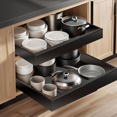 an open drawer with pots and pans on it in the middle of a kitchen