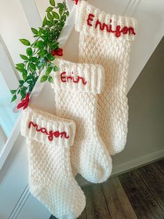 three white knitted stockings with red letters on them