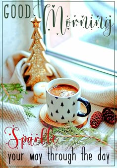 a cup of coffee sitting on top of a table next to a christmas tree