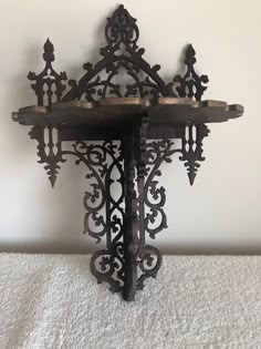 an ornate iron shelf with two candles on it