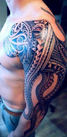 a man's chest with an intricate tattoo design on his left arm and shoulder