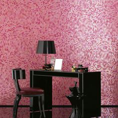 a desk and chair in front of a pink mosaic wall