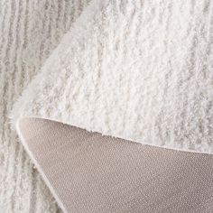 a close up view of a white blanket and pillow