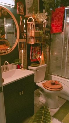 a bathroom with a toilet, sink and shower stall in the corner is decorated with colorful items