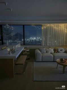 a living room filled with furniture next to a large window covered in string lights at night