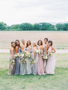 a group of women standing next to each other on top of a lush green field