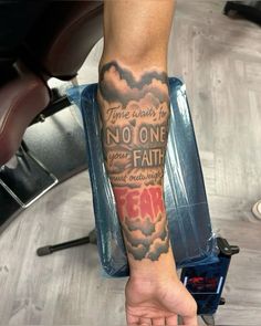 a person with a tattoo on their arm holding onto a piece of paper that says no one is your father