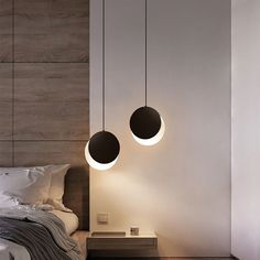 two round lights hanging from the ceiling above a bed