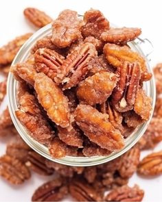 a glass bowl filled with pecans on top of a table