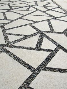 an intricately designed walkway with black and white tiles on the ground, in front of a building