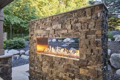 an outdoor fireplace with rocks surrounding it