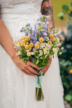 a woman holding a bouquet of flowers in her hands