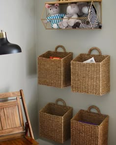 three baskets are hanging on the wall with stuffed animals in them