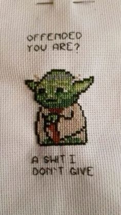 a white shirt with an embroidered yoda on it