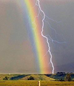 a rainbow appears to be in the sky with a lightning bolt coming from behind it