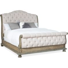 a bed with white linens and pillows on it's headboard, sitting in front of a white background