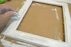 a person using a brush to paint a white frame