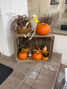 three wooden crates filled with pumpkins and gourds on the side of a building