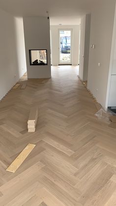 an empty room with hard wood flooring and a fire place in the corner on the far wall