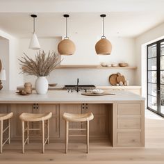 a large kitchen with wooden cabinets and stools in front of the island countertop