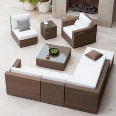 an outdoor living room with wicker furniture and white cushions on the outside patio area