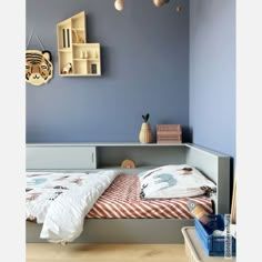 a bedroom with blue walls and white bedding in the corner, an animal themed wall hanging