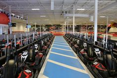 a row of go - karts lined up in a large room with blue and white flooring