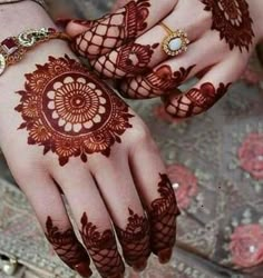 two hands with henna tattoos on them