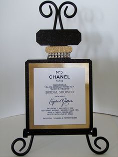 a black and gold wedding card holder with a wine bottle on it's stand