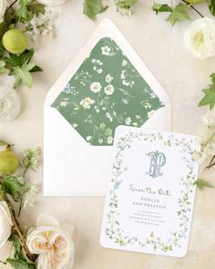 an envelope and wedding card with flowers on it, next to the letter p in green