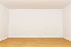 an empty room with white walls and wood floors