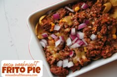 a casserole dish filled with ground beef, potatoes and onions in a white baking dish