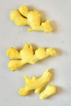 three pieces of yellow food sitting on top of a white counter next to each other