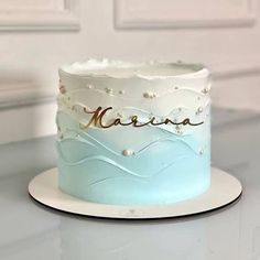 a blue and white cake sitting on top of a table next to a door with the name narra written on it