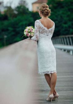 a woman in a white dress is standing on a bridge and looking at the sky