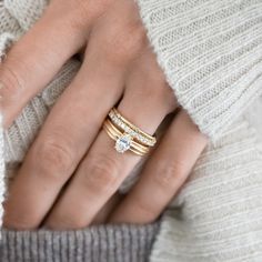 a woman's hand with three rings on her fingers and two diamonds in the middle