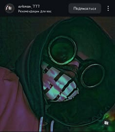 a gas mask with goggles on it is lit up in the dark, and there are other items inside