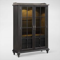 an antique black china cabinet with glass doors and gold trimmings on the top