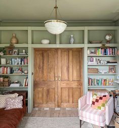 a living room filled with furniture and bookshelves next to a doorway that leads to a sitting area