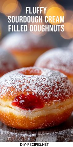 some powdered doughnuts with jelly on top and the words fluffy sourdough cream filled doughnuts