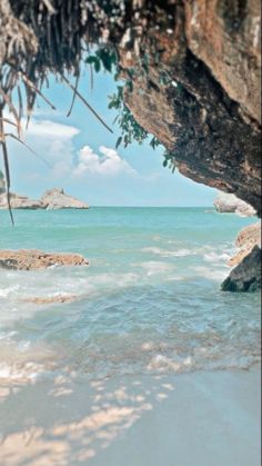 the water is crystal blue and clear with waves coming in from under it, as seen through a cave